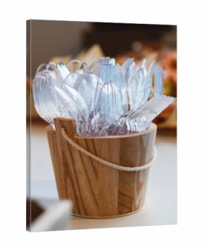 Close-up of plastic cutlery in a wooden bowl