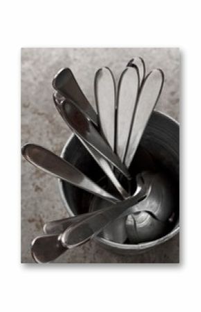 A metal cup with spoons