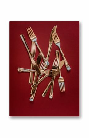 Golden cutlery on red background  