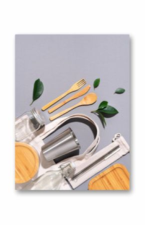 Sustainable lifestyle. Zero waste, plastic free shopping concept. Cotton bags, glass jar, bottle, metal cup, straws for drinking, bamboo cutlery and boxes on gray background.