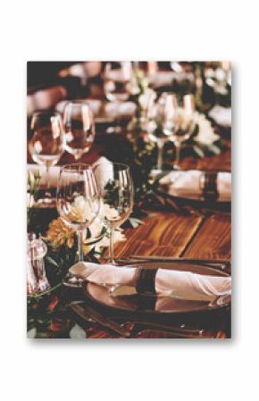 Wedding banquet, serving wooden table with silver plates and decorated with flowers