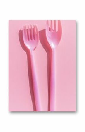 Disposable plastic utensils on pink background.