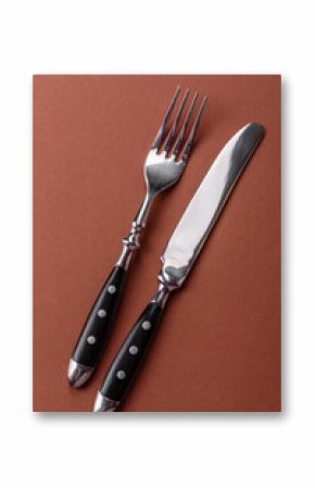 Knife and fork, cutlery on a brown dining table