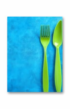 Green Plastic Fork and Spoon on Blue Background
