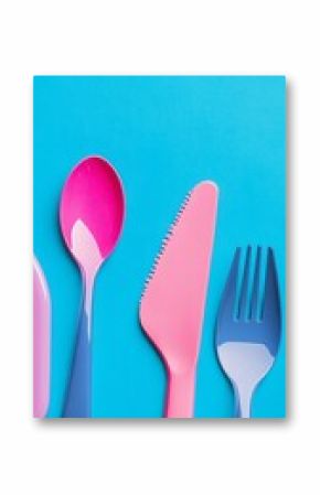 Colorful and modern plastic cutlery arranged on a vibrant blue background, perfect for showcasing dining or culinary themes in a playful and artistic way.