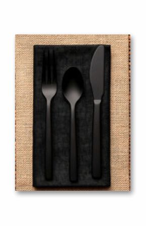 Black Cutlery on Burlap Napkin Against Brick Wall