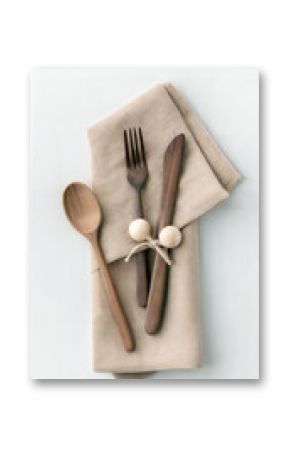 Wooden cutlery set on a beige napkin isolated on white background