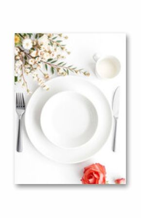 Elegant white table setting with floral decorations and cutlery arranged on a white surface