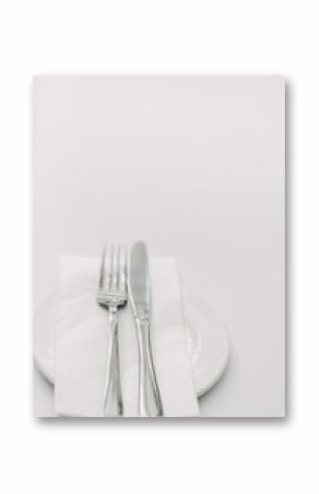 cutlery with napkin on a plate against a white background