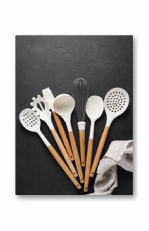 A set of kitchen utensils with a wooden handle on a black background. isolated object. top view, copy space