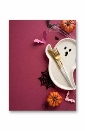 Halloween vertical table arrangement featuring a ghost-shaped plate, pumpkins, bats, spiderweb, and festive cutlery