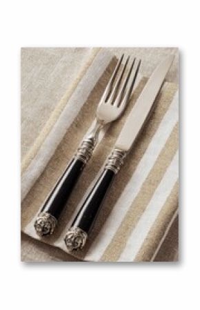 Elegant black-handled cutlery set on striped napkin
