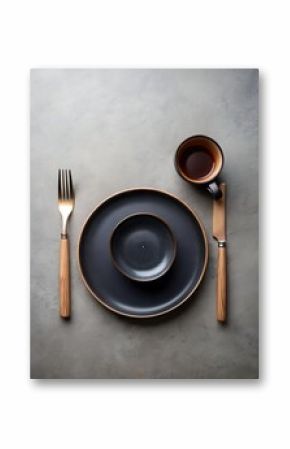 Elegant black tableware setting with wooden cutlery on a textured surface