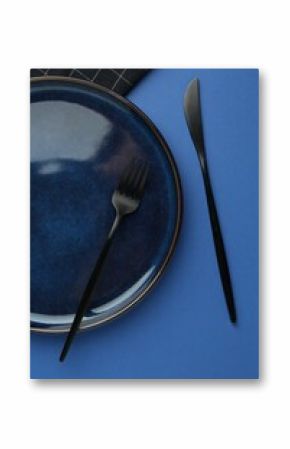 Stylish plate, cutlery and napkin on blue background, flat lay