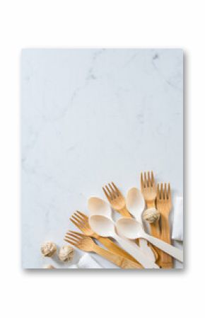 Eco friendly bamboo cutlery on white marble background with copy space