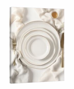 Stacked white plates with gold rims, draped in cream fabric, with cutlery