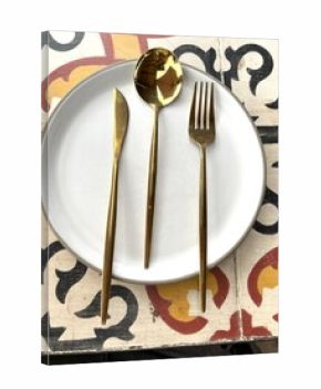 Modern Gold Cutlery on a White Plate and Tiled Table