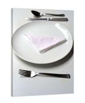 Table arranged with fork and knife, spoon, white plate