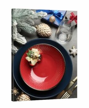 Christmas setting with plates, cutlery and festive decor on grey table, flat lay