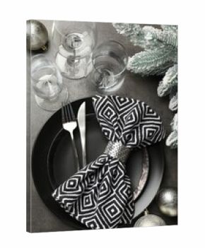 Christmas setting with plates, napkin, cutlery and festive decor on grey table, flat lay