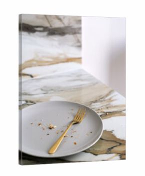 Elegant white dishes and gold cutlery on a stylish marble dining table