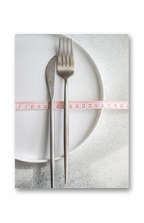 Top view of dieting essentials with measuring tape on white plate