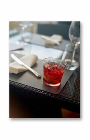 A refreshing cocktail on a textured table at an upscale restaurant with elegant cutlery and glassware in soft focus background, Naples, Italy