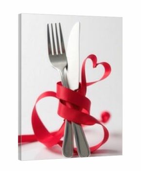 A lovely and romantic dining setup featuring a fork, knife, heart shape, and a beautiful ribbon