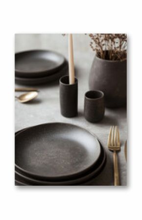 Elegant modern table setting with black ceramic dinnerware and minimalist decor