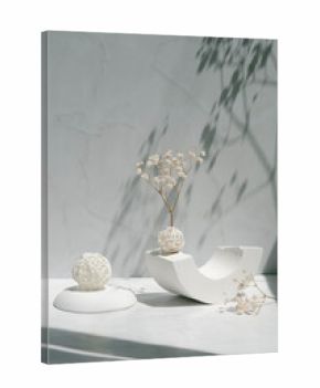 Interior still life with sunlight and shadows. Minimalist style. Gypsum geometric shape, decorative balls and gypsophila flowers on a gray background. 
