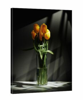 Vertical minimalistic still life shot of fresh yellow tulip flowers in transparent glass vase on table in gobo lighting
