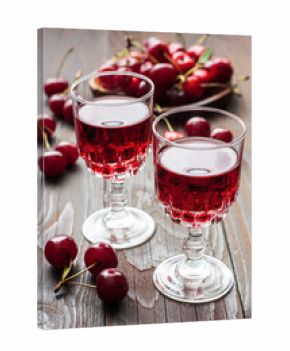  Liqueur in small glasses on the wooden table with fresh cherries