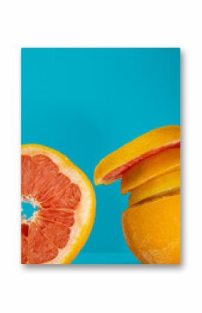 Orange and grapefruit on blue background still life