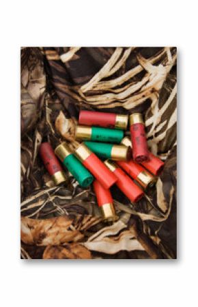 Still life shot of shotgun shells against camouflage clothing.