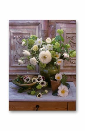 Still life of spring flowers on a marble table with wooden decorative carved background