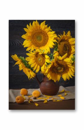 Still life with sunflowers in a clay pot against a wooden wall...