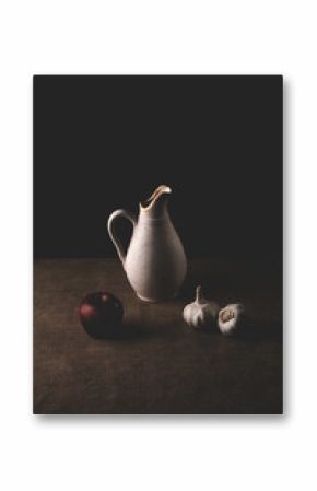 Still life containing garlic, vase and apples