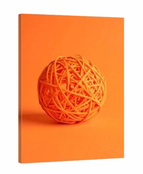 Orange ball of woven yarn on orange background