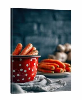 Red polka-dot bowl filled with fresh carrots, next to a plate of carrots and ginger