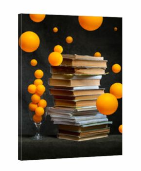 Still life with a stack of books and orange balloons