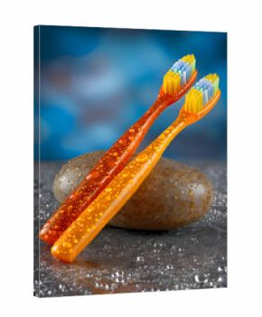 Wet Orange Toothbrushes on Stone Surface with Bokeh Background