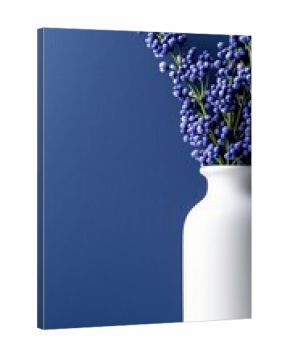A white vase holding a bouquet of purple Muscari flowers stands against a textured blue wall, illuminated by soft light.