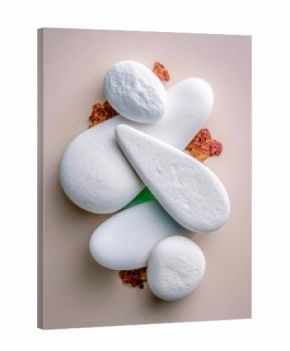 A minimalist composition featuring white stones arranged on a beige background, with a touch of coral-like texture.