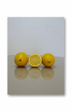 a group of green lemons on a table with reflection