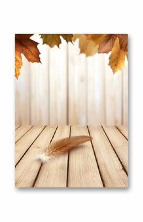 Autumn leaves and a feather on a rustic wooden table