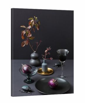 Decorative served set with dark cutlery, eggplants and bugs.