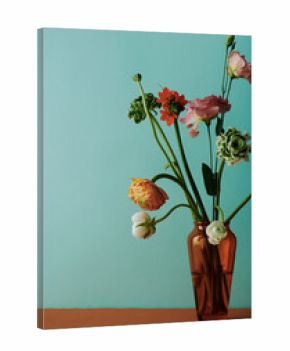 Vertical still life composition of flower bouquet in brown glass vase against light bluish green wall background