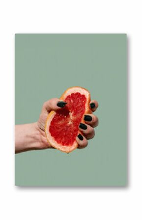 Woman hand holding and squeezing half of the grapefruit