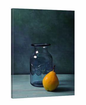 Still life with blue glass vase and fruits on turquoise background