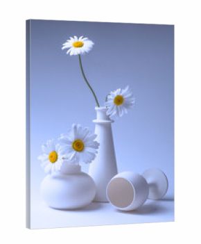 Blue still life with two vases, a wine glass and chamomile flowers.